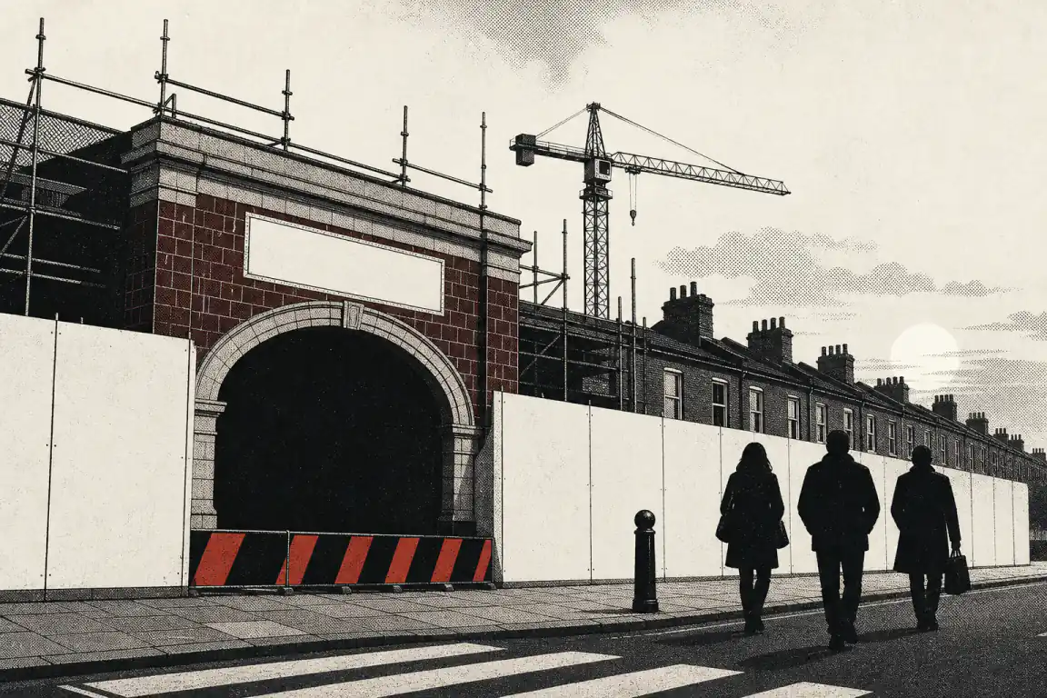 A tube station entrance stands sealed behind hoarding and a red-striped barrier, with scaffolding and a crane rising above it, while three commuters walk on past towards another station down a terraced street.